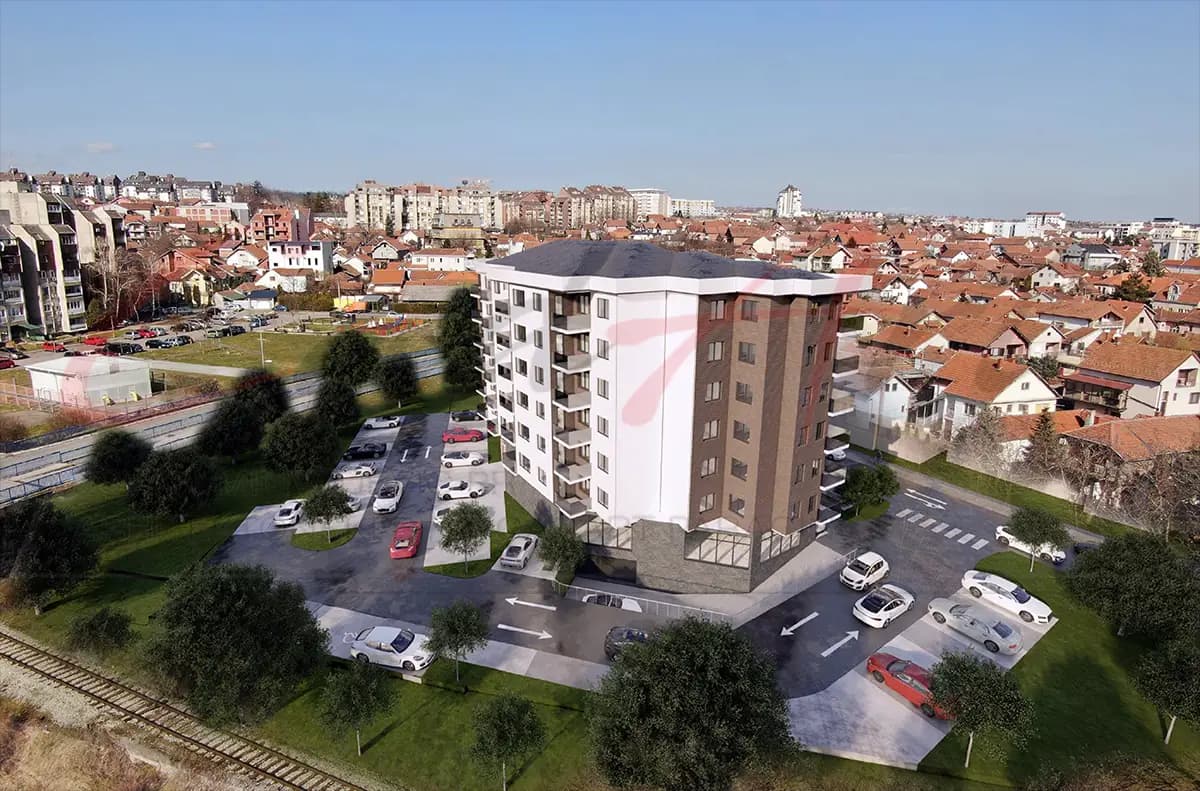 Photomontage of the design for a seven-story apartment building in Kragujevac, Serbia, set into a photograph of its site: aerial view of the site and the city beyond.
