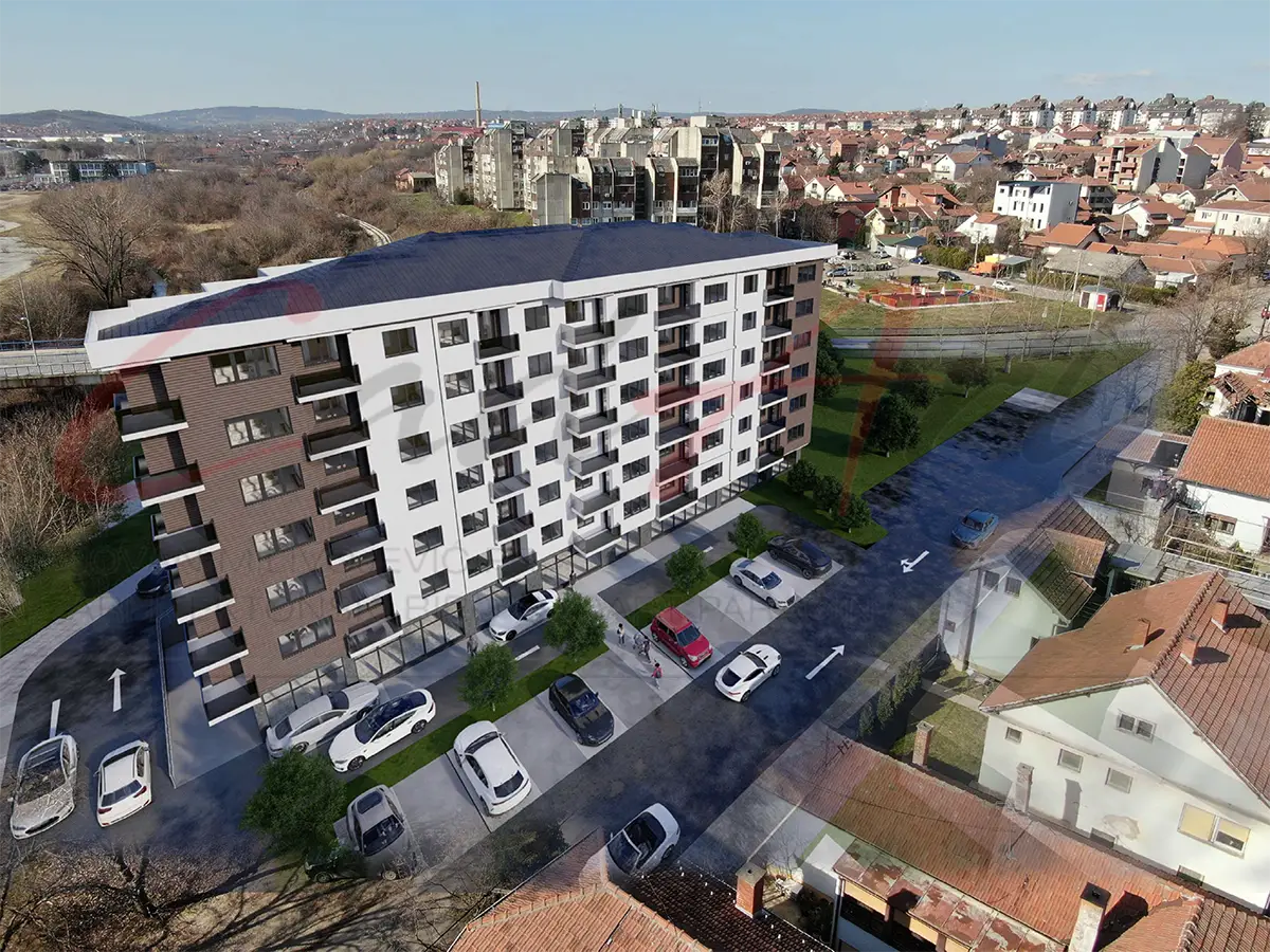 Photomontage of the design for a seven-story apartment building in Kragujevac, Serbia, set into a photograph of its site: aerial view with parking along the street.